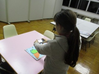 アイデア　写真　デジカメで児童の作品を撮影している様子